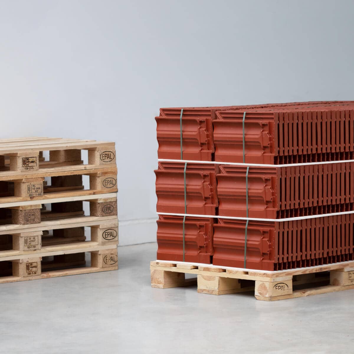 Industrial packaging roof tiles on pallet with intermediate layers of solid cardboard laminated with foam